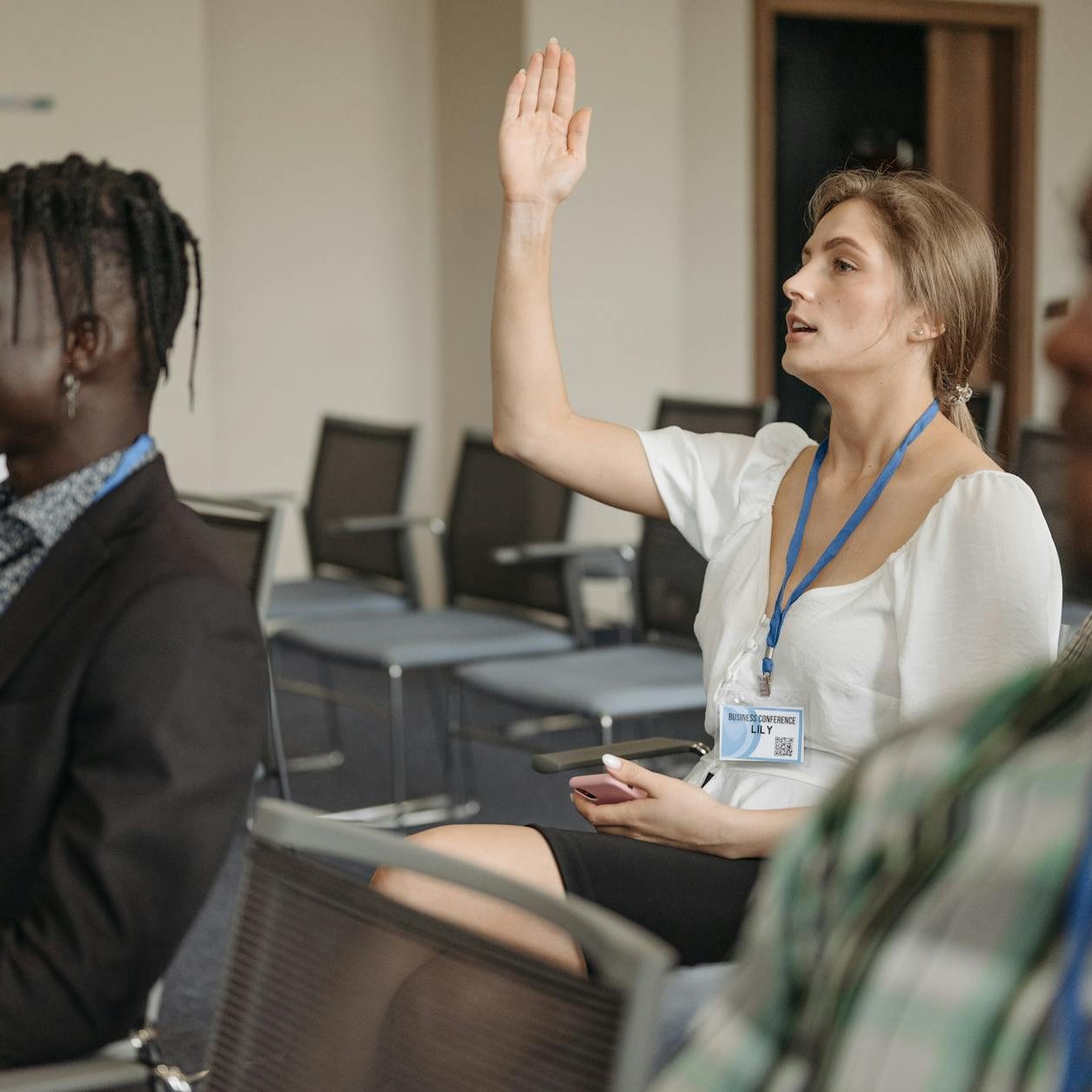 a woman in white shirt raising her hand